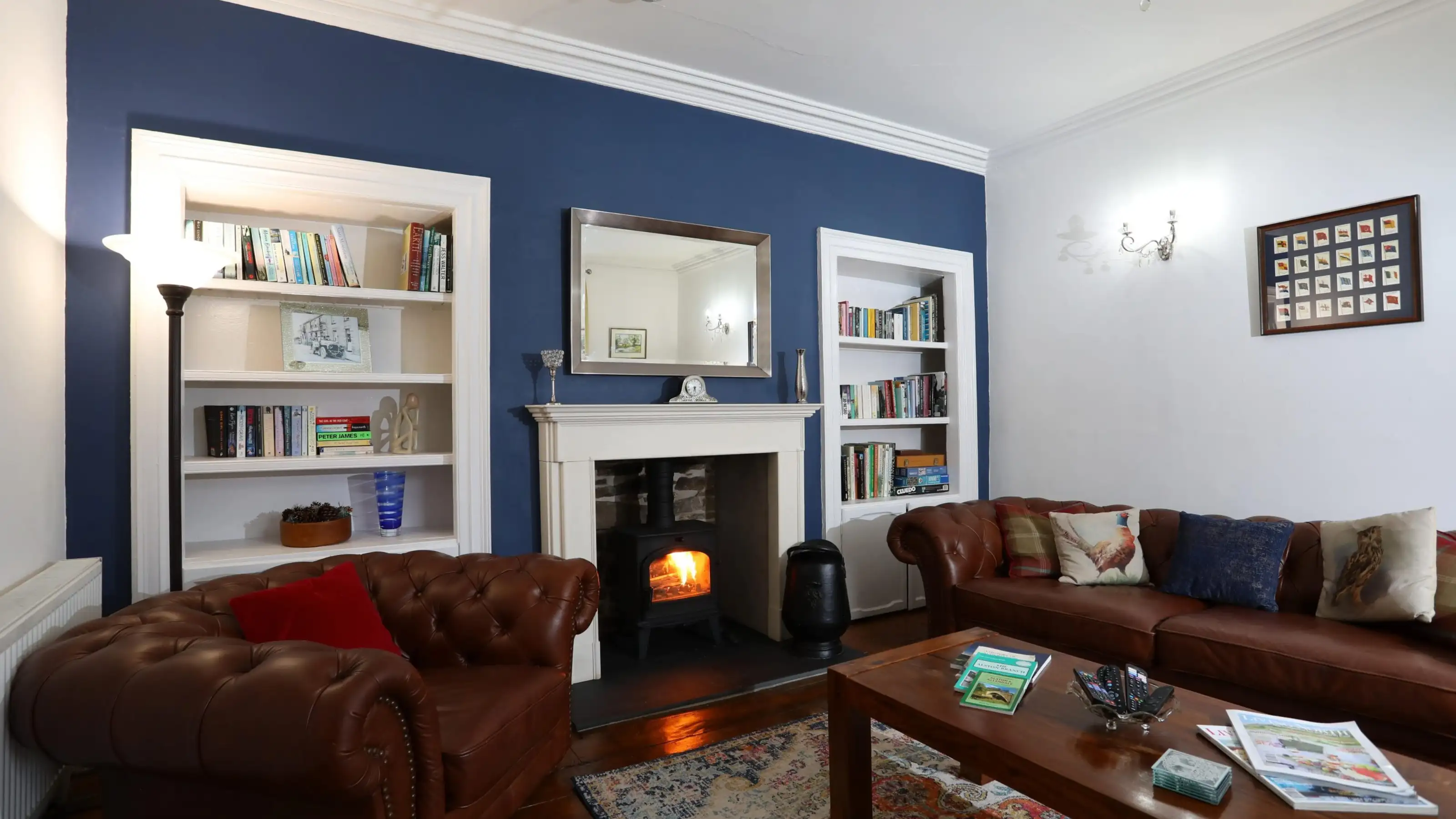 Cosy holiday let lounge with leather sofas and a lit log burner, kept guest-ready by Straight Up Stays